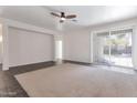 Spacious open-plan living room featuring tile flooring, white walls, and sliding glass doors at 9121 W Alvarado St, Phoenix, AZ 85037