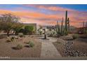 Beautiful Southwestern home with desert landscaping, including cacti, trees, and a decorative water feature at 9870 E Little Nugget Way, Gold Canyon, AZ 85118