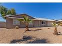 Charming single-story home with desert landscaping and small, young palm trees at 13232 N 40Th Pl, Phoenix, AZ 85032