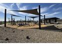 Community playground area featuring a shaded structure with multiple play zones at 15657 W Deanne Dr, Waddell, AZ 85355