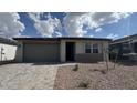 Charming single-story home with a two-car garage, low maintenance desert landscaping, and paver driveway at 15761 W Beryl Ave, Waddell, AZ 85355