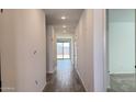 A long hallway with wood-look tile flooring, bright lighting, and access to various rooms at 15761 W Beryl Ave, Waddell, AZ 85355