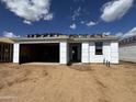 Unfinished exterior featuring an attached garage, covered entry, and material for roof installation at 15772 W Beryl Ave, Waddell, AZ 85355