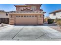 Two-car garage featuring decorative carriage lights and a concrete driveway at 162 N 225Th Dr, Buckeye, AZ 85326