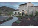 Beautiful stone home exterior with a desert landscaped yard and a paved walkway at 17957 W Long Lake Rd, Goodyear, AZ 85338