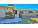 Inviting front yard with mature landscaping and a paved walkway to the front door at 18034 N Highwood Ct, Sun City, AZ 85373