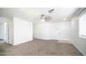 Inviting living room features plush carpeting, a ceiling fan, and ample natural light at 2803 W Angela Dr, Phoenix, AZ 85053