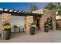 A welcoming outdoor seating area and stone archway frames the ornate front door at 3348 E Eva St, Phoenix, AZ 85028