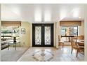 Inviting foyer with decorative tile floor and ornate front doors, with views to living and dining areas at 3348 E Eva St, Phoenix, AZ 85028