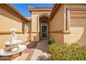 Inviting front entrance with a security screen door, beautiful landscaping, and a charming decorative fountain at 3350 W Ivanhoe Ct, Chandler, AZ 85226