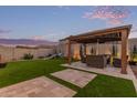 Backyard featuring covered patio with seating, mature trees, manicured lawn, and outdoor play area at 3483 W Verde River Rd, San Tan Valley, AZ 85144