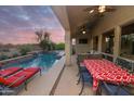 Covered patio with dining and lounge areas overlooking a tranquil pool and desert landscape at 4251 E Desert Forest Trl, Cave Creek, AZ 85331