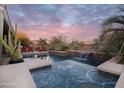 Relaxing pool with waterfall feature surrounded by desert landscaping with a beautiful sky view at 4251 E Desert Forest Trl, Cave Creek, AZ 85331