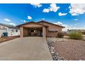 A tan single-story home boasts a front carport, low-maintenance desert landscape, and a spacious driveway at 485 S Pino Cir, Apache Junction, AZ 85120