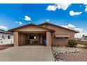 Single-story tan home with a front carport, a low-maintenance desert landscape, and a spacious driveway at 485 S Pino Cir, Apache Junction, AZ 85120