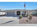 Inviting single-story home with a two-car garage, desert landscaping, and quaint front porch seating at 5121 N 181St Dr, Litchfield Park, AZ 85340