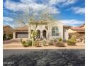 Charming single-story stucco home featuring manicured landscaping, tiled roof and a delightful arched entry at 9266 E Desert Village Dr, Scottsdale, AZ 85255