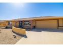 Inviting home featuring a two-car garage and a charming front patio area at 9513 W Cottonwood Dr, Sun City, AZ 85373