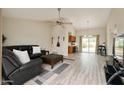 Inviting living room with a large leather sofa, modern fan, and bright natural light at 1016 E Utopia Rd, Phoenix, AZ 85024