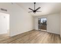 Bright bedroom featuring wood floors, a ceiling fan, and sliding doors leading to a private balcony with neighborhood views at 10610 S 48Th St # 2001, Phoenix, AZ 85044