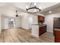 Open-concept living room boasts wood floors, fan, and sliding doors to a balcony, flowing to an updated kitchen with a breakfast bar at 10610 S 48Th St # 2001, Phoenix, AZ 85044