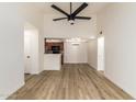 Spacious, open-concept living room with modern wood flooring, a ceiling fan, and easy access to a convenient kitchen at 10610 S 48Th St # 2001, Phoenix, AZ 85044