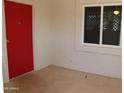 Close up of the covered entry with bright red door and window at 10621 N 115Th Ave, Youngtown, AZ 85363