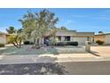 Inviting single-story home with mature trees and landscaped front yard at 11029 W Palmeras Dr, Sun City, AZ 85373