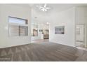 Bright living room featuring neutral carpeting, modern ceiling fan, and vaulted ceilings at 14610 N 87Th Ave, Peoria, AZ 85381