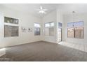 Spacious living room featuring plush carpeting, many windows, and a modern ceiling fan at 14610 N 87Th Ave, Peoria, AZ 85381