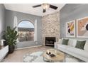 Bright living room with a stone fireplace, a large window, and contemporary furniture at 1718 S Longmore -- # 41, Mesa, AZ 85202