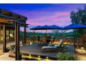 Beautiful backyard with pergola, lounge seating, dining table and chairs, and landscaped garden at sunset at 2034 N Dome Rock --, Mesa, AZ 85207