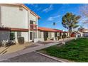 Exterior view of multiple homes with red roofs, desert landscaping and green grass at 2842 E Beck Ln # 2, Phoenix, AZ 85032