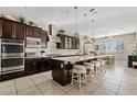 Spacious kitchen features stainless steel appliances, island with bar stools, and ample cabinet space at 3117 E Sagebrush St, Gilbert, AZ 85296