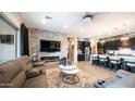 Open-concept living space with a stone accent wall, modern fireplace, and a glimpse of the kitchen at 40195 N Hailey Ln, Queen Creek, AZ 85140