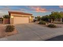 Single-Gathering home with a long driveway, desert landscaping, and a two-car garage at 4937 S Peach Willow Ln, Gilbert, AZ 85298