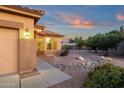 Single-Gathering home with desert landscaping, rock features, and a beautiful blue and orange sunset at 4937 S Peach Willow Ln, Gilbert, AZ 85298