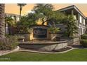 Entrance to The Carlyle Condominium with a beautifully landscaped sign and mature trees at 5303 N 7Th St # 215, Phoenix, AZ 85014