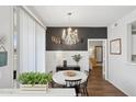 Chic dining area with a chandelier, white table, and dark accent wall creating a stylish ambiance at 5303 N 7Th St # 215, Phoenix, AZ 85014