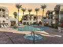 Resort-style pool area with palm trees, lounge chairs, and jacuzzi, creating a relaxing oasis at 5303 N 7Th St # 215, Phoenix, AZ 85014