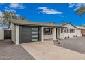 Charming home featuring a modern garage door, fresh white paint and desert landscaping at 6926 E Moreland St, Scottsdale, AZ 85257