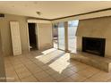 Living room featuring tile floors, sliding glass doors, and a cozy fireplace at 7615 W Palmaire Ave, Glendale, AZ 85303