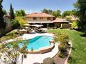 Inviting backyard with lush landscaping, manicured lawn, outdoor kitchen, and a sparkling pool at 8373 S Forest Ave, Tempe, AZ 85284