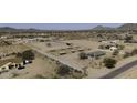 Aerial view of a horse property featuring covered stalls, a central building, and surrounding desert landscape at 9066 N Thunderbird Rd, Maricopa, AZ 85139