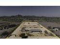 Drone shot of desert horse property, highlighted by boundary lines, covered stalls, and a central building at 9066 N Thunderbird Rd, Maricopa, AZ 85139