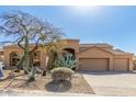 A sprawling tan house with mature desert landscaping, arched entry, and three-car garage at 11743 E Desert Vista Dr, Scottsdale, AZ 85255