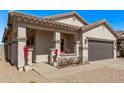 Charming home with front porch, covered entry, gray garage door, and easy care landscaping at 1366 W Santa Gertrudis Trl, San Tan Valley, AZ 85143