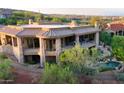 A multi-level home features stone accents, balconies, a pool, and mature landscaping at 15827 E Firerock County Club Dr, Fountain Hills, AZ 85268