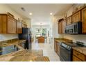 Well-lit kitchen with granite countertops, wood cabinets, and modern appliances at 16495 W Monteverde Ln, Surprise, AZ 85374