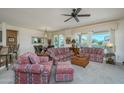 Bright and airy living room featuring large windows, neutral walls, and comfortable, colorful seating at 16495 W Monteverde Ln, Surprise, AZ 85374